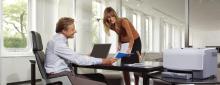 A woman and man talking in a business office.